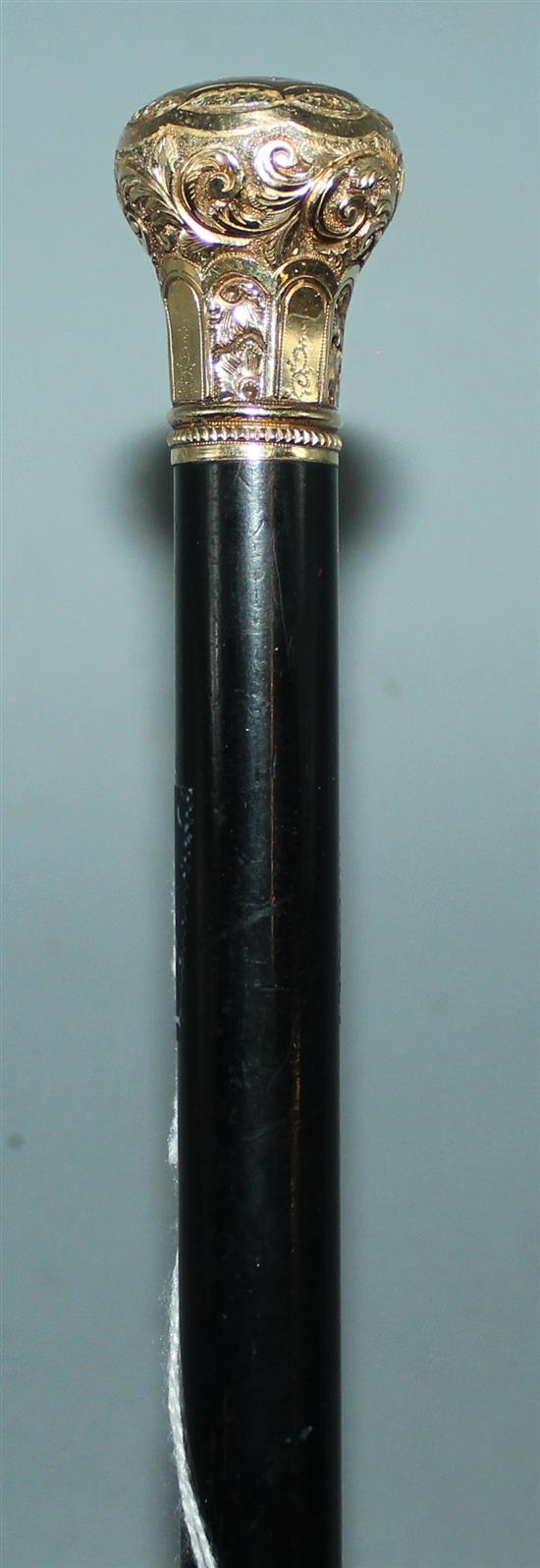 A gold-topped ebony walking cane